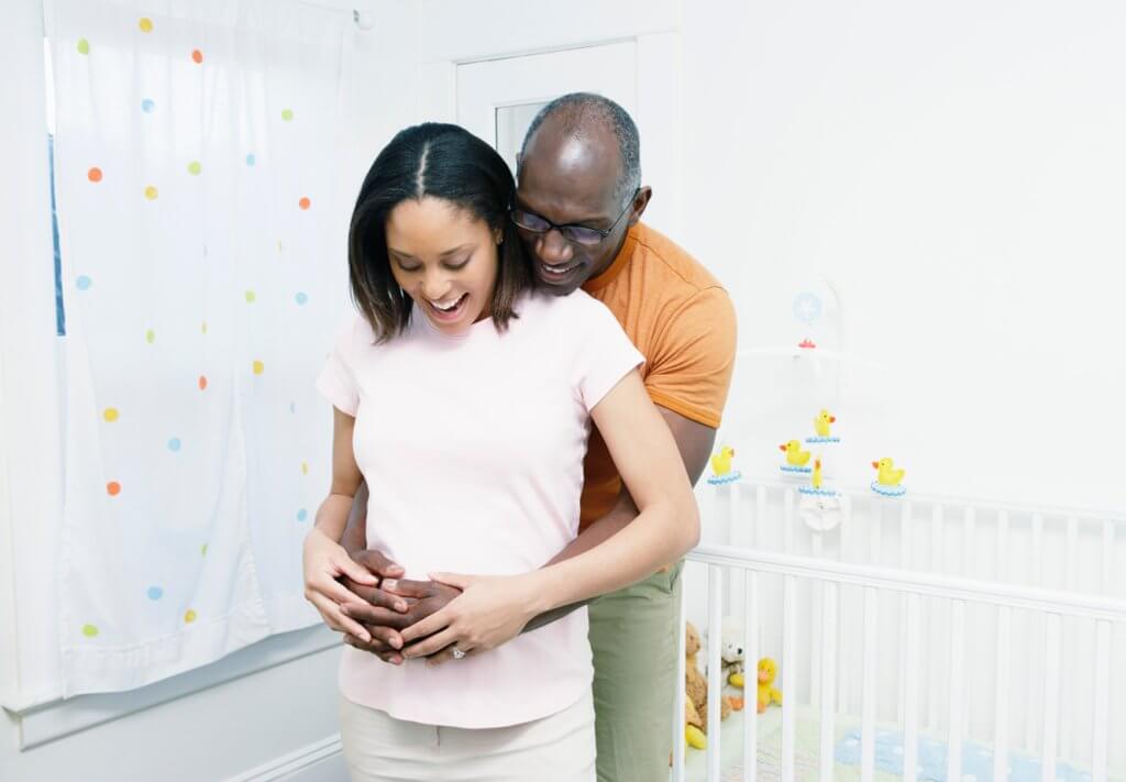 Photo of a dad embrasing mom's pregnant stomach